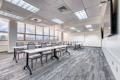 Meeting room with tables and chairs set up in classroom style seating.